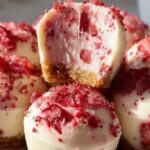 Smooth Strawberry Cheesecake Bites are the perfect no-bake dessert when you crave something creamy, fruity, and irresistibly indulgent. These mini cheesecake treats combine a buttery graham cracker base with a light, fluffy strawberry cheesecake filling that melts in your mouth. Simple to prepare and elegant to serve, they are ideal for gatherings, celebrations, or a sweet personal treat. Why You Will Love This Recipe These cheesecake bites are effortless yet impressive. With no oven required, they save time while delivering bakery-style results. The balance between the crunchy crust and the silky strawberry filling creates a delightful contrast in every bite. They are portion-controlled, easy to store, and perfect for entertaining. Kitchen Tools You Will Need • Mixing bowls (medium and large) • Electric hand mixer or stand mixer • Spatula • Mini muffin liners or silicone molds • Measuring cups and spoons • Refrigerator Ingredients • 1 cup graham cracker crumbs • 3 tablespoons unsalted butter, melted • 8 ounces cream cheese, softened • 1/4 cup granulated sugar • 1 teaspoon vanilla extract • 1/2 cup heavy cream (cold) • 1 cup fresh strawberries, finely chopped • 2 tablespoons powdered sugar Step-by-Step Instructions 1. In a medium bowl, combine graham cracker crumbs and melted butter. Mix until evenly coated. 2. Press the crumb mixture firmly into mini muffin liners or silicone molds to form the crust. Refrigerate to set. 3. In a large bowl, beat the cream cheese until smooth and creamy. Add granulated sugar and vanilla extract. Mix well. 4. In a separate bowl, whip the cold heavy cream until stiff peaks form. 5. Gently fold the whipped cream into the cream cheese mixture until light and fluffy. 6. Fold in the finely chopped strawberries and powdered sugar carefully. 7. Spoon the cheesecake filling over the chilled crusts and smooth the tops. 8. Refrigerate for at least 4 hours or until fully firm. 9. Garnish with fresh strawberry slices or a light dusting of powdered sugar before serving. Tips for Perfect Cheesecake Bites • Always use cold heavy cream to achieve better volume when whipping. • Finely chop strawberries to prevent excess moisture in the filling. • Allow full chilling time to ensure clean, firm bites. • For extra flavor, add a small squeeze of fresh lemon juice to brighten the taste. Flavor Variations and Additions Add melted white chocolate to the filling for extra richness. Swap strawberries with raspberries or blueberries for a different fruity twist. For a chocolate version, mix mini chocolate chips into the batter or drizzle dark chocolate on top. Storage Instructions Store Smooth Strawberry Cheesecake Bites in an airtight container in the refrigerator for up to 4 days. They can also be frozen for up to 2 months. Thaw overnight in the refrigerator before serving. Reheating is not recommended as this is a chilled dessert. Nutritional Information (Approximate per bite) • Calories: 180 kcal • Fat: 12g • Carbohydrates: 15g • Protein: 3g • Sugar: 10g Preparation Time Prep Time: 20 minutes Chilling Time: 4 hours Total Time: 4 hours 20 minutes Servings: 12 bites Frequently Asked Questions Can I make these cheesecake bites ahead of time? Yes, they can be prepared a day in advance and kept refrigerated until serving. Can I use frozen strawberries? Fresh strawberries are recommended for best texture, but if using frozen, thaw and drain thoroughly. How do I prevent a runny filling? Ensure the whipped cream reaches stiff peaks and allow adequate chilling time. Final Tip Patience during chilling is the secret to achieving that smooth, creamy texture. Let them rest properly, and you will be rewarded with perfectly set, luxurious cheesecake bites every single time.